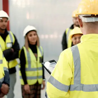 A group of construction workers standing next to each other having a meeting