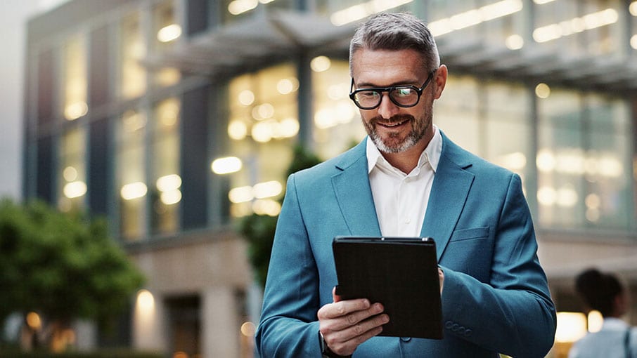 A person in a suit holding a tablet.